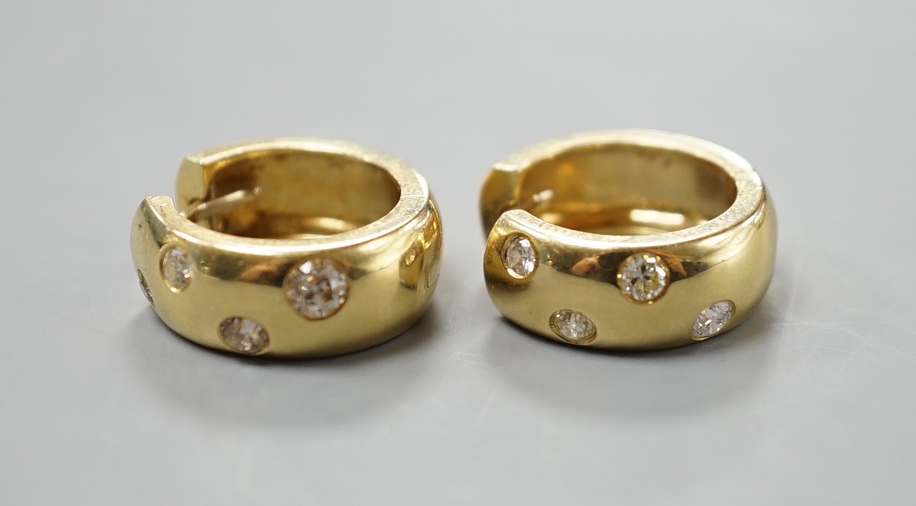 A modern pair of 750 yellow metal and four stone gypsy set diamond hoop earrings, 16mm, gross weight 11 grams.